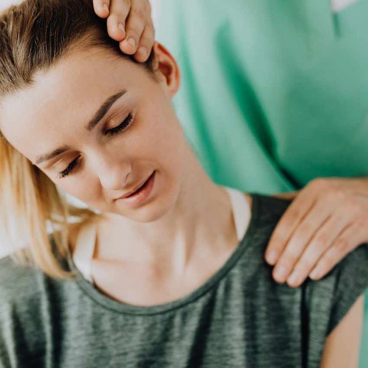 Physiotherapist gently treating an older patient's neck and shoulder